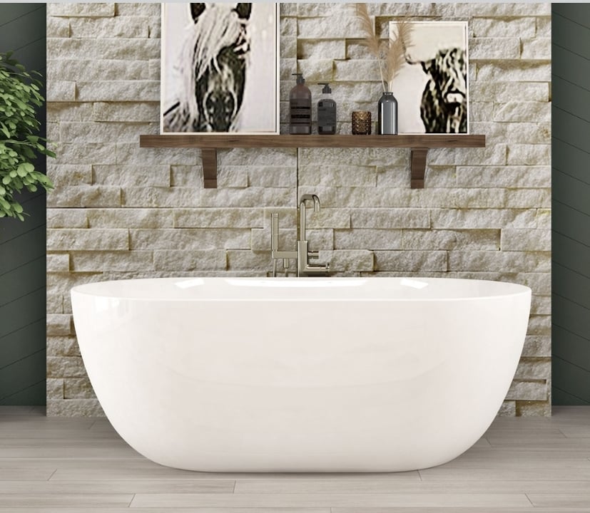 white bath tub with stone wall